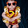 baby, child, sunglasses, heart_shaped, costume, yellow, orange, question_mark, sitting, barefoot, blue_blanket, cute, portrait, funny, fashion, indoor, one_person, serious, infant, playful