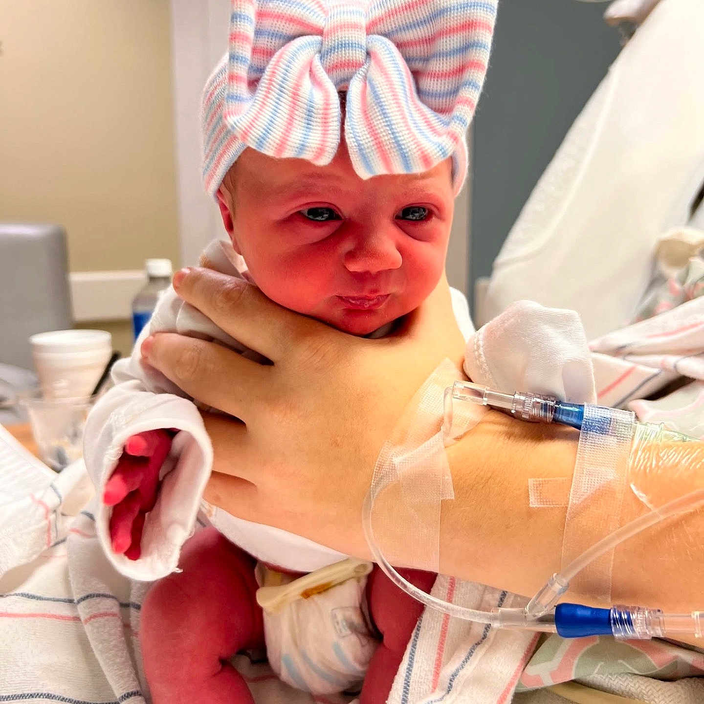 Raelynn joined the competition — help win amazing prizes! newborn, baby, infant, hospital, medical, iv_line, hand, bow, striped_bow, diaper, bed, blanket, patient, person, cute, indoors, healthcare, closeup, skin, portrait