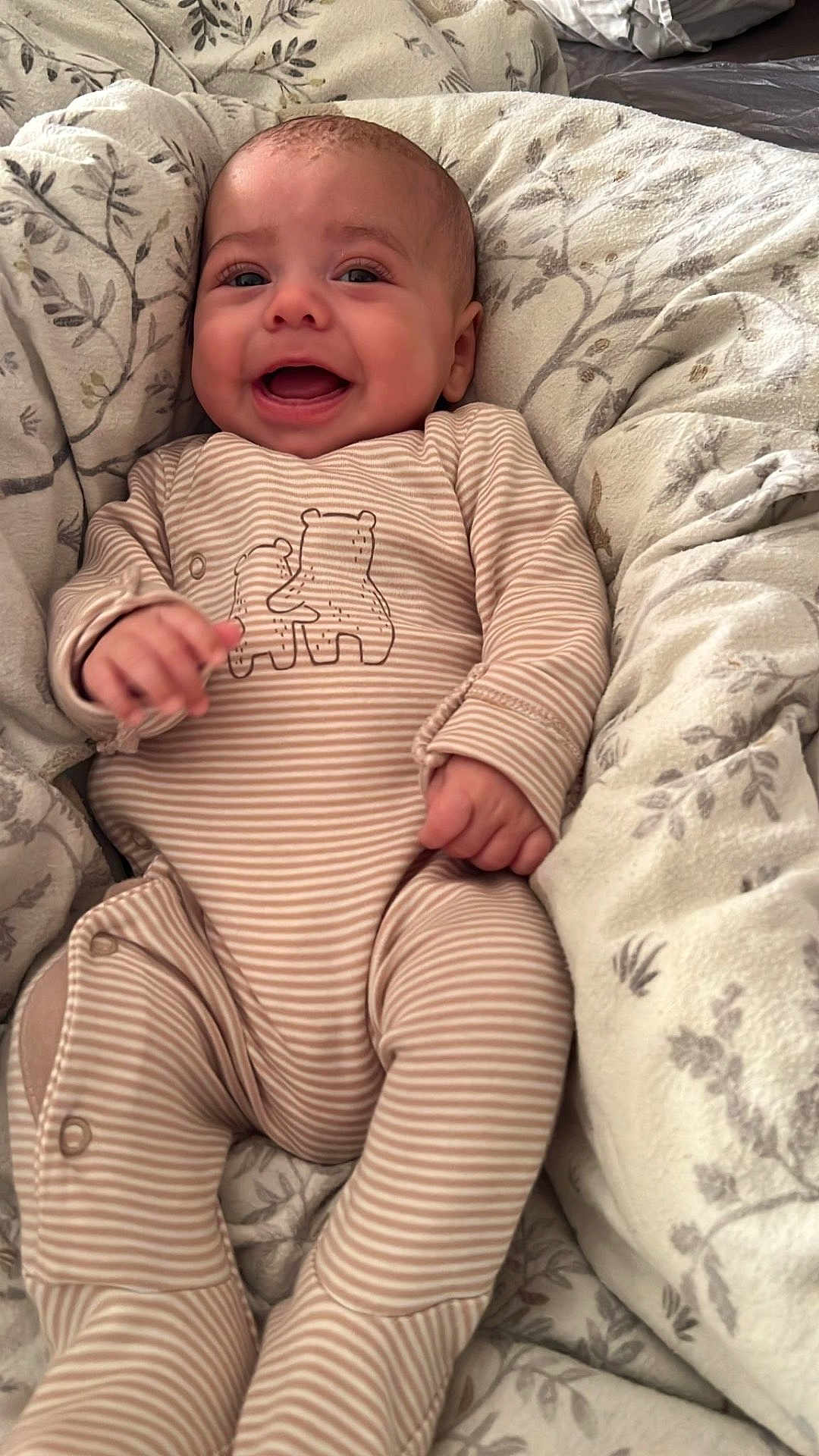 Ruben joined the competition — help win amazing prizes! baby, infant, smiling, onesie, striped_clothing, bear_illustration, blanket, cozy, happy, cute, child, bed, soft, patterned_blanket, lying_down, small_hands, human, indoor, relaxed, joyful