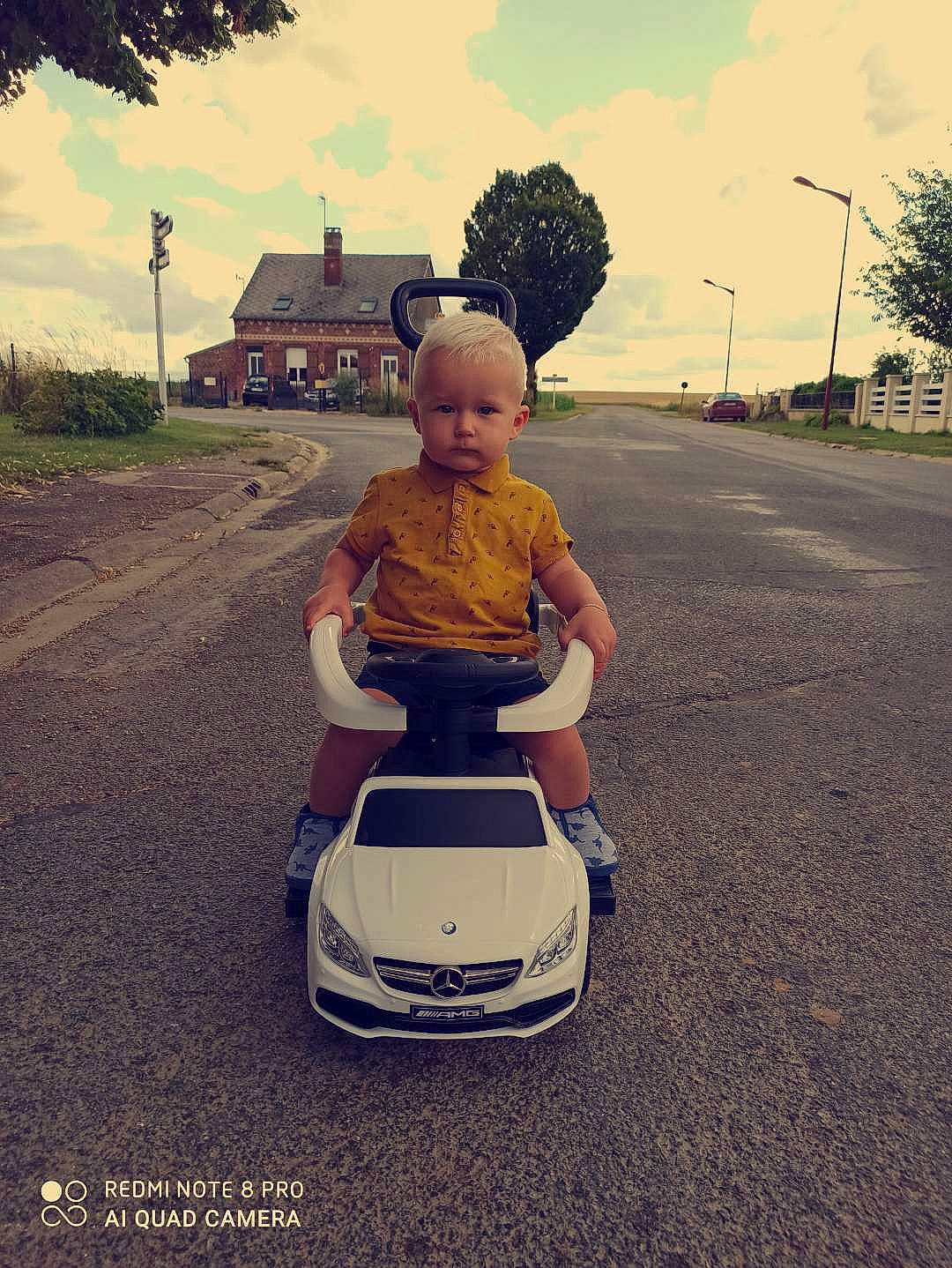Maël participe au concours pour gagner de l'argent avec cette photo : asphalt, automotive_design, car, child, cloud, family_car, happy, landscape, motor_vehicle, person, photography, shoe, sitting, sky, smile, summer, toddler, tree, vacation, vehicle