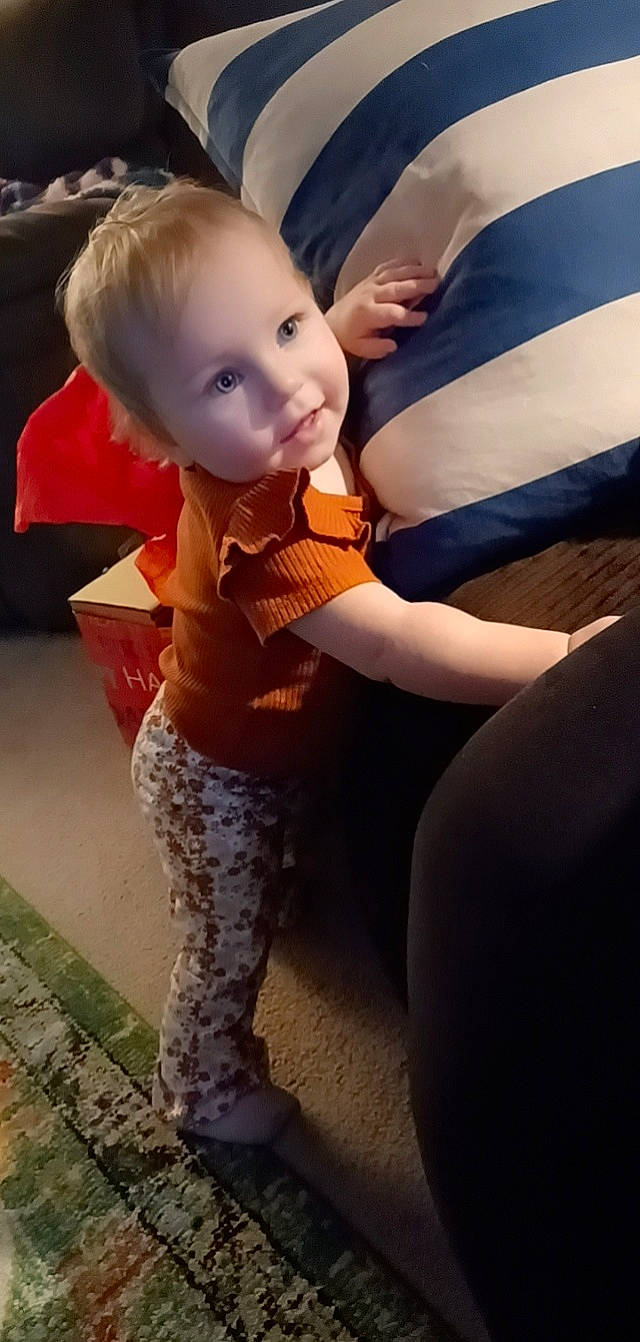 Alanni is registered to the contest to win money with this photo: baby, blond, child, fictional_character, flooring, fun, fur, gesture, hair, happy, head, human_body, human_leg, knee, lap, person, sitting, thigh, toddler, trunk