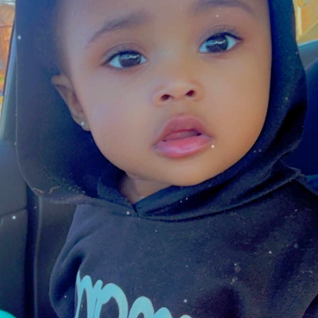 Raiyn is registered to the contest to win money with this photo: baby, bodypart, bonnet, cap, clothing, coat, face, finger, hand, hat, head, hood, hoodie, jacket, knitwear, person, photography, portrait, sweater, sweatshirt