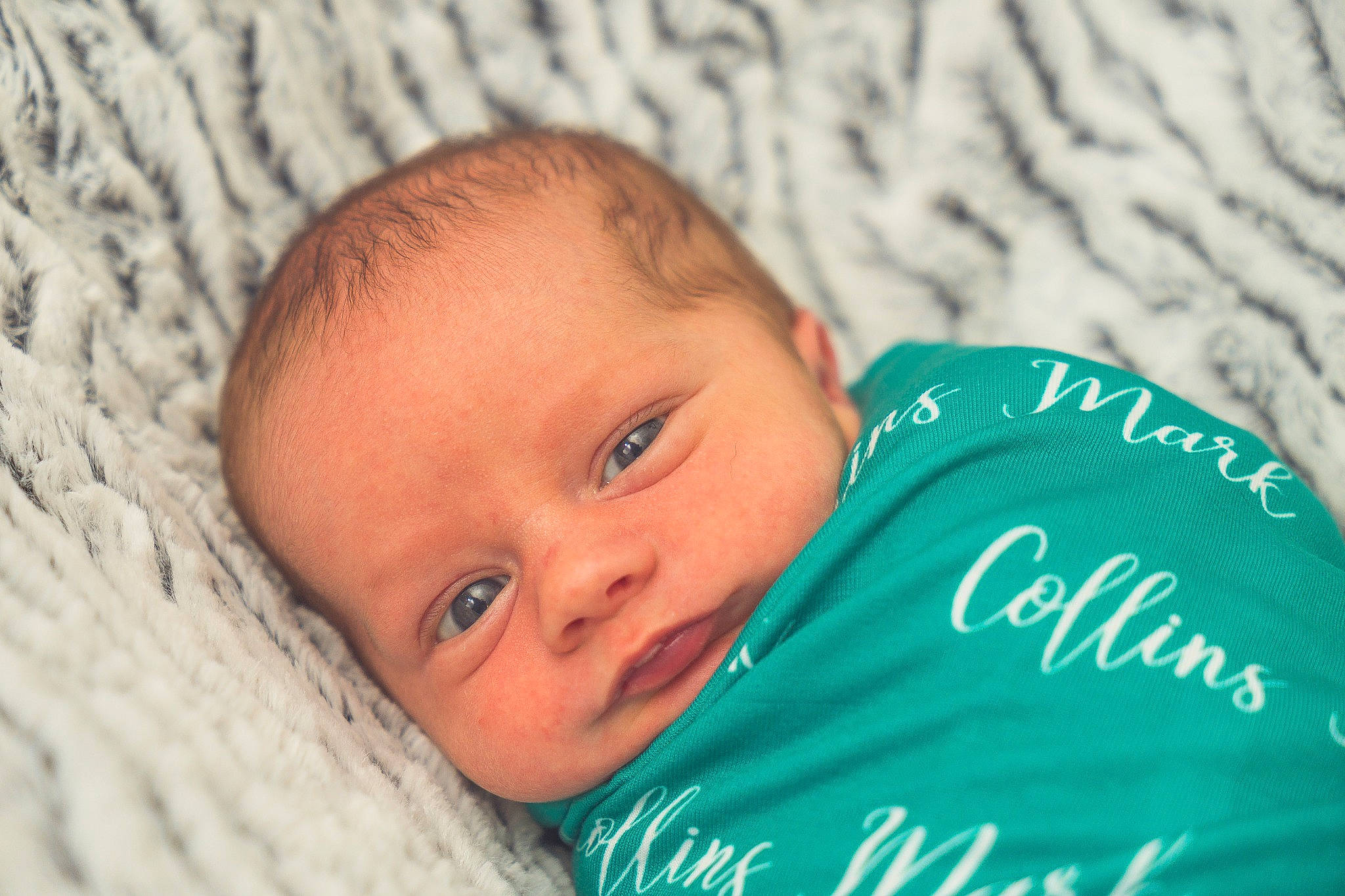 Collins is registered to the contest to win money with this photo: baby, cheek, child, chin, comfort, eye, face, facial_expression, grass, happy, iris, linens, nose, person, portrait_photography, room, skin, smile, toddler, wood