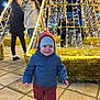 David a rejoint le concours — aidez-le/la à gagner de superbes lots ! child, toddler, smiling, winter_clothing, jacket, hat, pants, shoes, outdoor, night, lights, festive, decoration, people, pavement, happy, walking, crowd, celebration, event