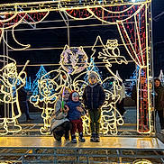 David participe au concours pour gagner de l'argent avec cette photo : child, children, holiday_lights, night, balloon, winter_clothing, festive, outdoor, illumination, smile, beanie, jacket, platform, metal_structure, decorations, tree, owl, elf, people, crowd