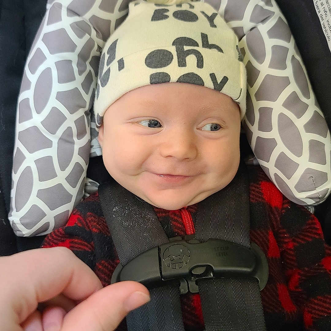 Colt is registered to the contest to win money with this photo: baby, bodypart, cap, clothing, coat, cushion, face, finger, gun, hand, hat, head, homedecor, jacket, machine, person, photography, portrait, weapon, wheel