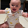 baby, infant, smiling, happy, onesie, fruit_pattern, sitting, carpet, child, cute, indoors, portrait, cheerful, young, person, skin, face, head, arms, legs