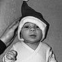 baby, black_and_white, blanket, cute, eyes, face, festive, fingers, hand, headwear, holiday, indoor, infant, lying_down, mouth, nose, portrait, santa_hat, soft_texture, white_clothing