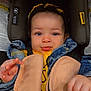 baby, child, car_seat, denim_jacket, toy, beads, headband, curly_hair, smile, face, hand, straps, safety, infant, cute, portrait, indoor, clothing, closeup, seatbelt