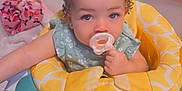 Gianna is registered to the contest to win money with this photo: toddler, baby, pacifier, hair_clips, baby_walker, indoor, child, curious, green_clothing, yellow_cushion, pink_clip, face, person, young_child, seated, home, playtime, cute, infant, portrait