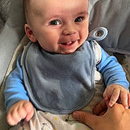 Kayden is registered to the contest to win money with this photo: baby, bib, blanket, child, clothing, comfort, cute, expression, eyes, face, fingers, hand, happy, holding, indoors, infant, person, seat, skin, smile