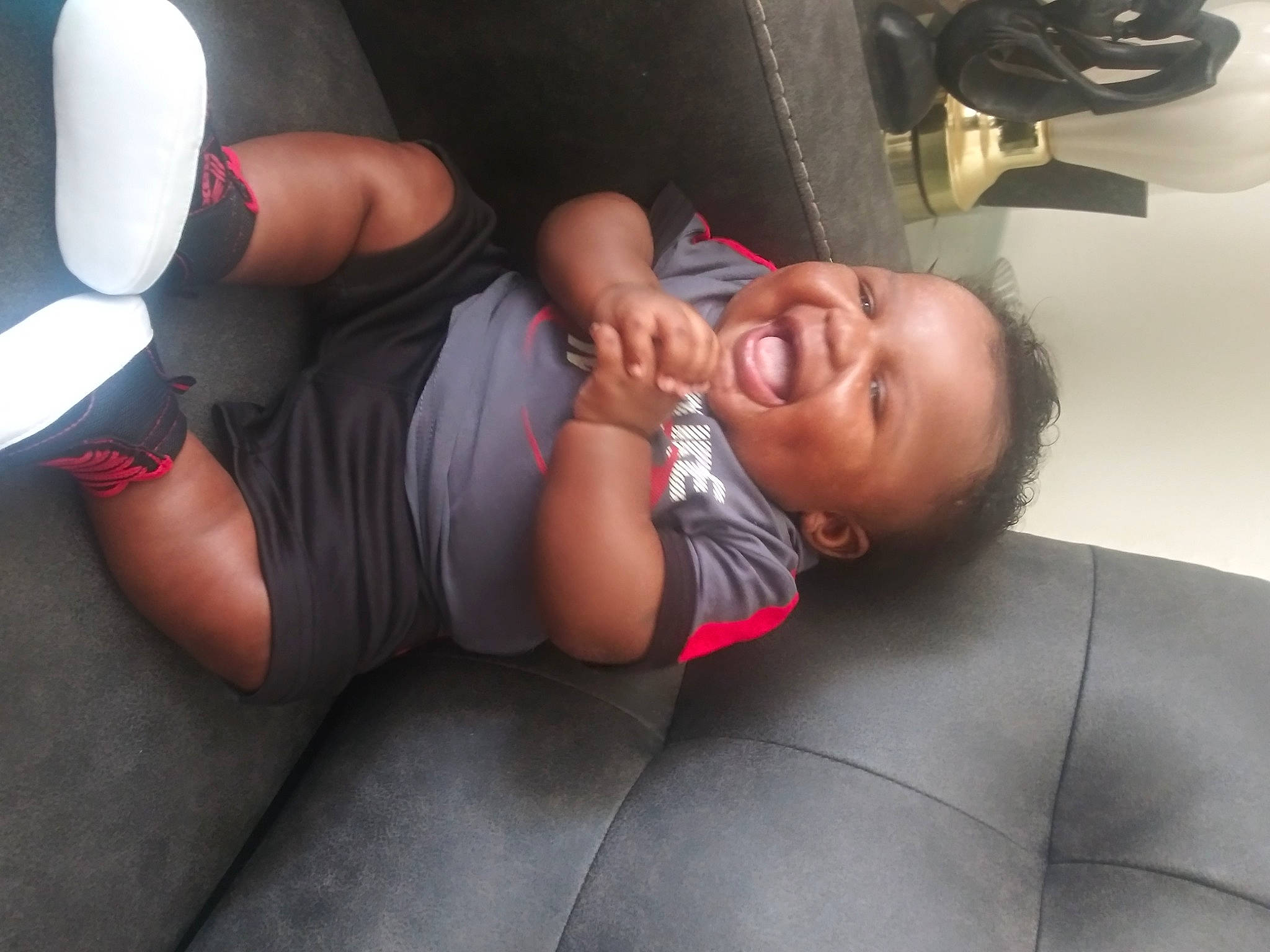 Tyson is registered to the contest to win money with this photo: baby, chest, child, comfort, elbow, flash_photography, flooring, foot, fun, gesture, grass, human_leg, knee, person, shorts, sitting, smile, sportswear, thigh, toddler