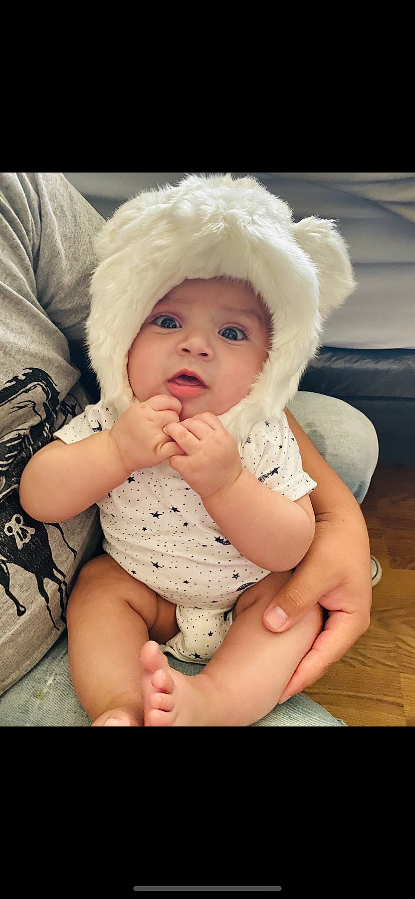 Maliki joined the competition — help win amazing prizes! baby, bonnet, cap, cheek, child, eye, finger, fur, hand, hat, headgear, headwear, lip, nose, person, sitting, skin, smile, toddler
