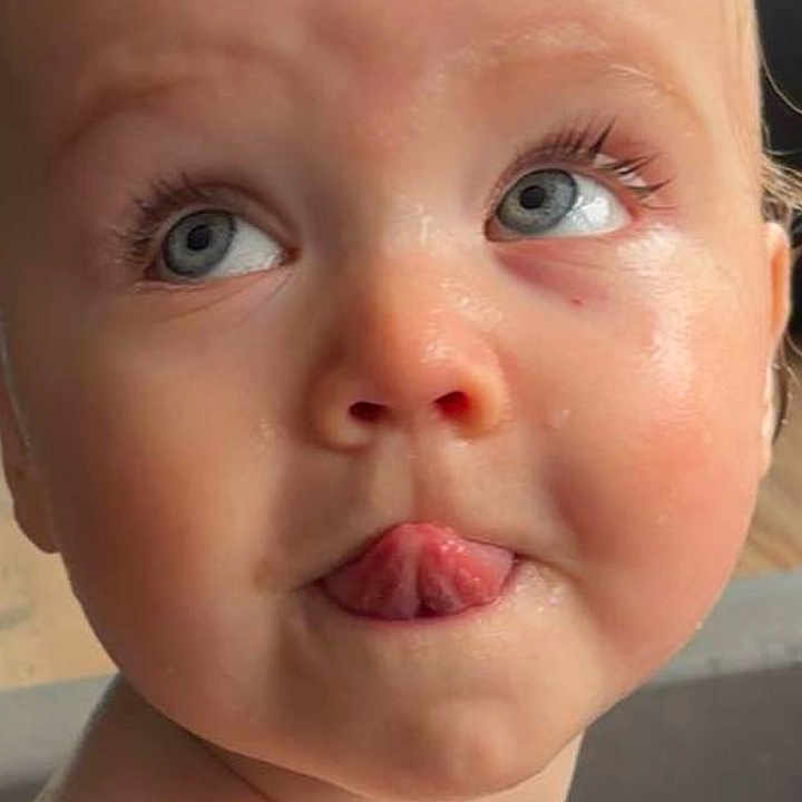 Koa is registered to the contest to win money with this photo: baby, blue_eyes, child, close_up, curious, cute, expression, face, head, indoors, infant, mischievous, person, playful, portrait, skin, tongue, water, wet_skin, young