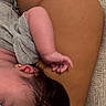 baby, sleeping, arm, earring, skin, hand, resting, close_up, soft_texture, human, infant, peaceful, toddler, skin_tone, hair, gray_clothing, cushion, comfort, relaxation, intimate