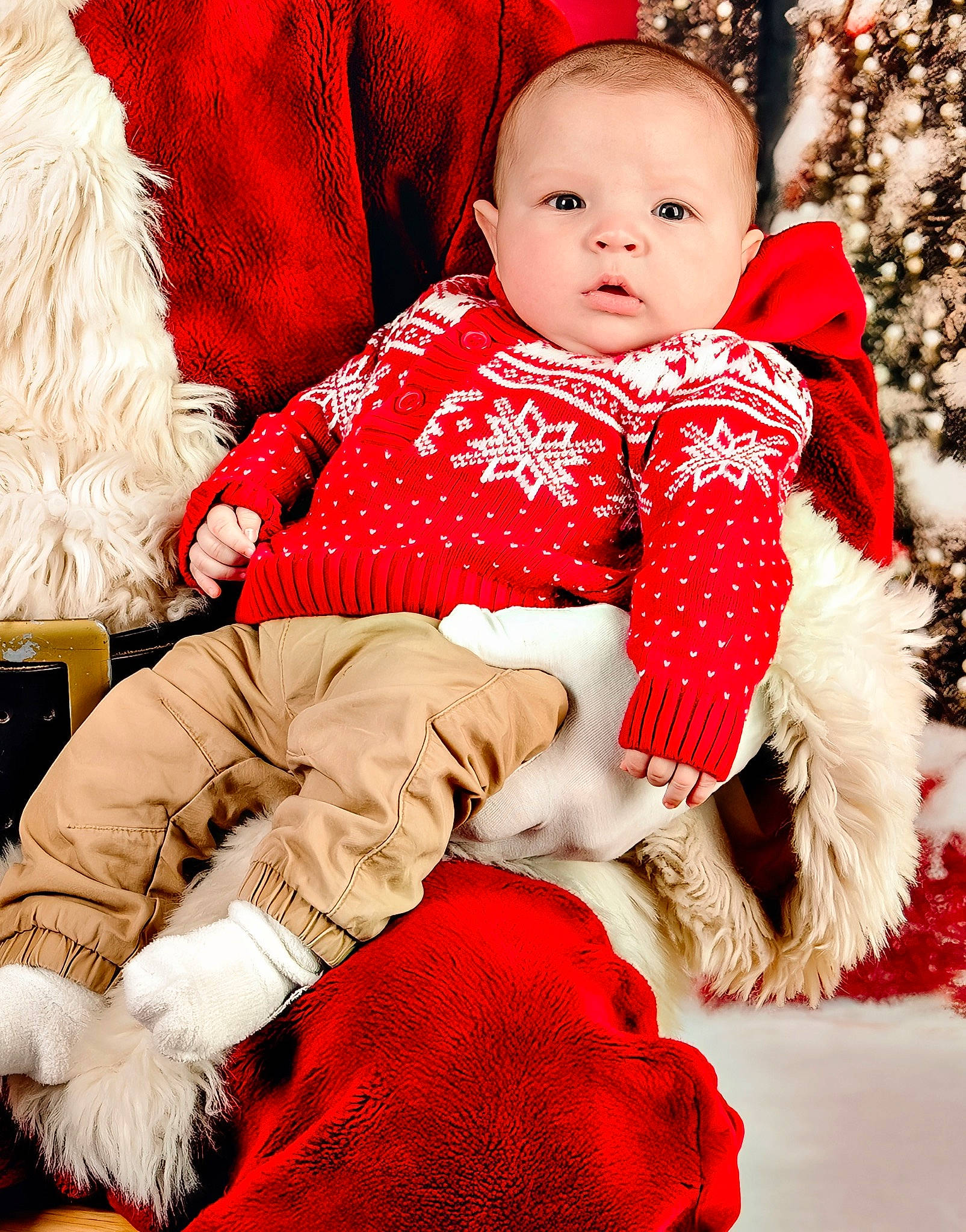 Deacon is registered to the contest to win money with this photo: baby, baby_toddler_clothing, child, christmas_decoration, collar, comfort, event, face, fur, fur_clothing, happy, head, holiday, human_body, pattern, person, red, sitting, sleeve, toddler