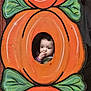 child, toddler, pumpkin, cutout, face, orange, green_leaves, curious, thoughtful, portrait, costume, autumn, holiday, decoration, outdoor, cute, young_child, baby, person, festive