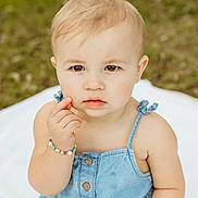 Miley joined the competition — help win amazing prizes! toddler, child, denim_dress, bracelet, outdoor, blanket, grass, cute, portrait, baby, person, skin, face, expression, sitting, young_child, summer, casual_clothing, natural_light, curious
