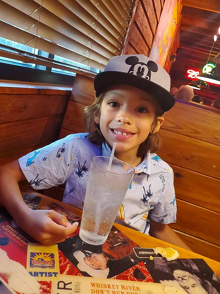 Kevin Jr is registered to the contest to win money with this photo: alcoholic_beverage, cap, child, cocktail, distilled_beverage, drink, drinking, drinkware, event, fashion_accessory, food, fun, happy, hat, headwear, ingredient, joy, junk_food, liqueur, person