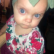 Mazie joined the competition — help win amazing prizes! baby, child, face, blue_eyes, head_wrap, floral_shirt, curious, indoor, dim_lighting, person, portrait, close_up, hand_holding, furniture, home, expression, young, cute, infant, clothing