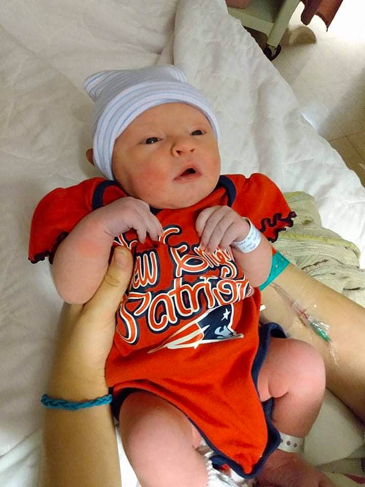 Liberty Lewis is registered to the contest to win money with this photo: abdomen, baby, baby_sleeping, baby_toddler_clothing, cap, child, comfort, elbow, finger, happy, headwear, jersey, mouth, orange, person, skin, sleeve, textile, thigh, toddler
