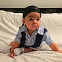 Liam participe au concours pour gagner de l'argent avec cette photo : baby, child, infant, striped_shirt, navy_vest, head_wrap, white_blanket, sitting, curious_expression, indoors, cute, portrait, sock, soft_texture, crawling_position, small_hands, big_eyes, face, person, cozy