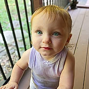 Aria joined the competition — help win amazing prizes! baby, child, toddler, portrait, face, blue_eyes, blond_hair, looking_at_camera, serious_expression, outdoor, deck, balcony, railing, wooden_floor, sunlight, sleeveless_shirt, lavender_clothing, gray_pants, toy, close_up