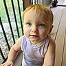 baby, child, toddler, portrait, face, blue_eyes, blond_hair, looking_at_camera, serious_expression, outdoor, deck, balcony, railing, wooden_floor, sunlight, sleeveless_shirt, lavender_clothing, gray_pants, toy, close_up