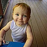 Aria is registered to the contest to win money with this photo: toddler, child, baby, portrait, smiling, happy, blue_eyes, blond_hair, indoor, wooden_floor, blue_table, sitting, standing, sleeveless_shirt, lavender_clothing, face, hands, arms, natural_light, home