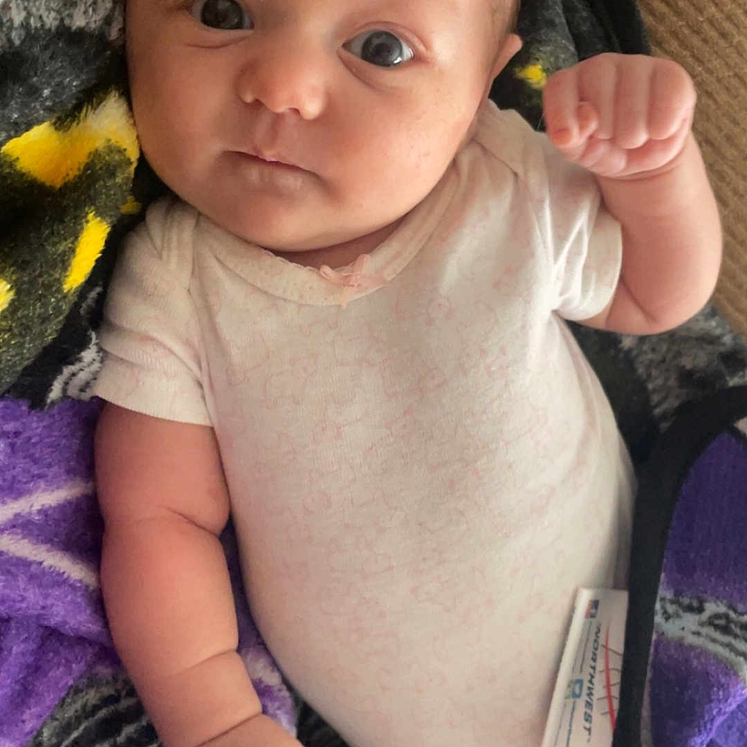 Maeves is registered to the contest to win money with this photo: accessories, baby, bed, bedroom, blanket, bodypart, bracelet, clothing, couch, crib, cushion, cutlery, diaper, earring, face, finger, frown, furniture, glove, hand