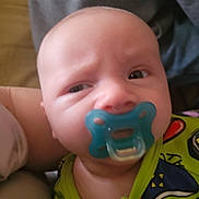 Skyler joined the competition — help win amazing prizes! baby, pacifier, infant, face, person, clothing, colorful, closeup, expression, child, young, cute, skin, head, eyes, mouth, wearing, indoor, holding, puzzled