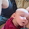 Skyler is registered to the contest to win money with this photo: baby, sleeping, pacifier, red_shirt, striped_clothing, adult, black_tank_top, jeans, couch, beige, indoor, resting, comfort, close_up, person, child, relaxation, casual_clothing, face, peaceful