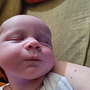 Skyler is registered to the contest to win money with this photo: arm, baby, bed, blanket, cheek, close_up, fabric, face, indoors, infant, mole, mouth, newborn, nose, peaceful, portrait, resting, skin, sleeping, soft_light