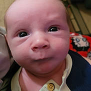 Skyler is registered to the contest to win money with this photo: baby, infant, face, eyes, clothing, button, closeup, indoor, person, portrait, skin, head, expression, newborn, curious, young, child, human, apparel, blanket