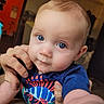 baby, blue_eyes, drool, hand, infant, close_up, shirt, colorful, indoor, person, cute, child, skin, face, expression, support, young, portrait, curious, casual