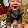 baby, child, smiling, happy, indoors, carpet, blanket, hoodie, camouflage, feet, hands, door, floor, person, infant, cute, portrait, expression, young, home