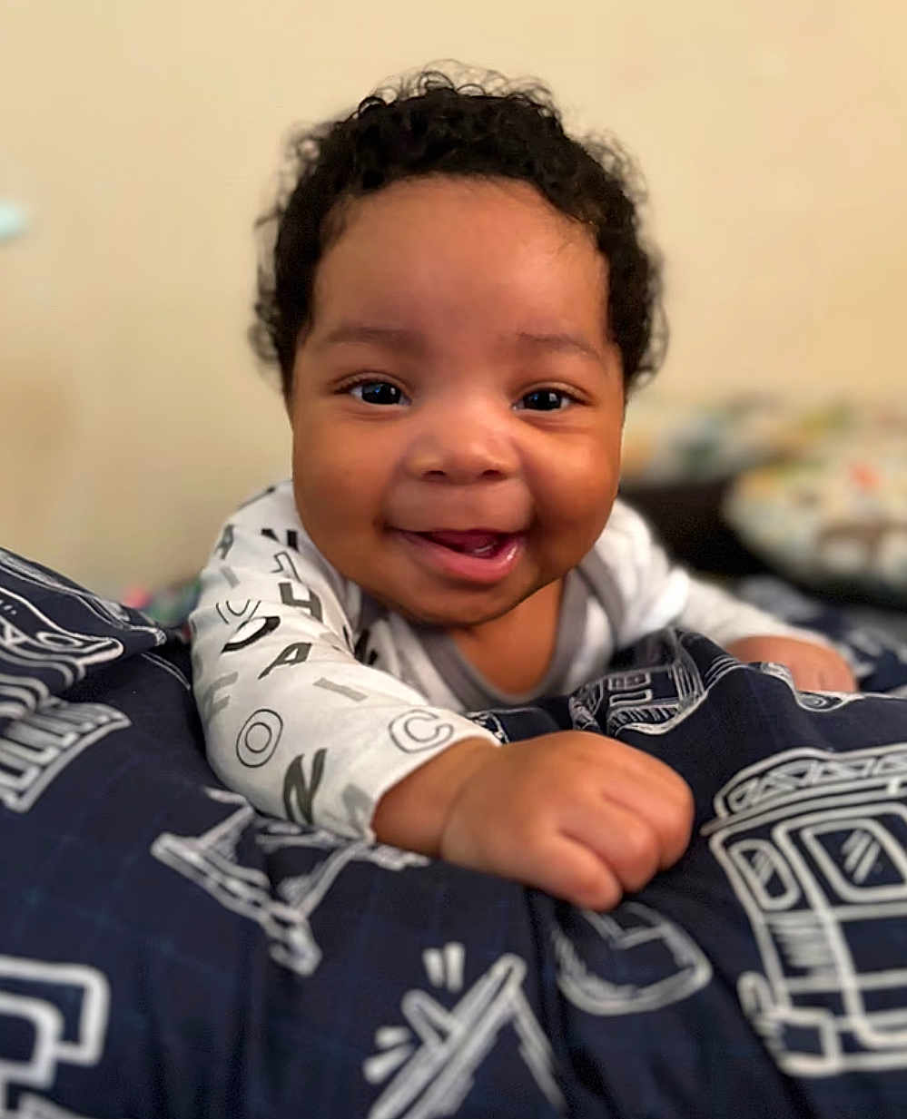 Cailand joined the competition — help win amazing prizes! baby, smiling, curly_hair, infant, blanket, indoor, happy, child, closeup, face, person, patterned_blanket, cute, young_child, hand, crawling, portrait, toddler, skin, clothing