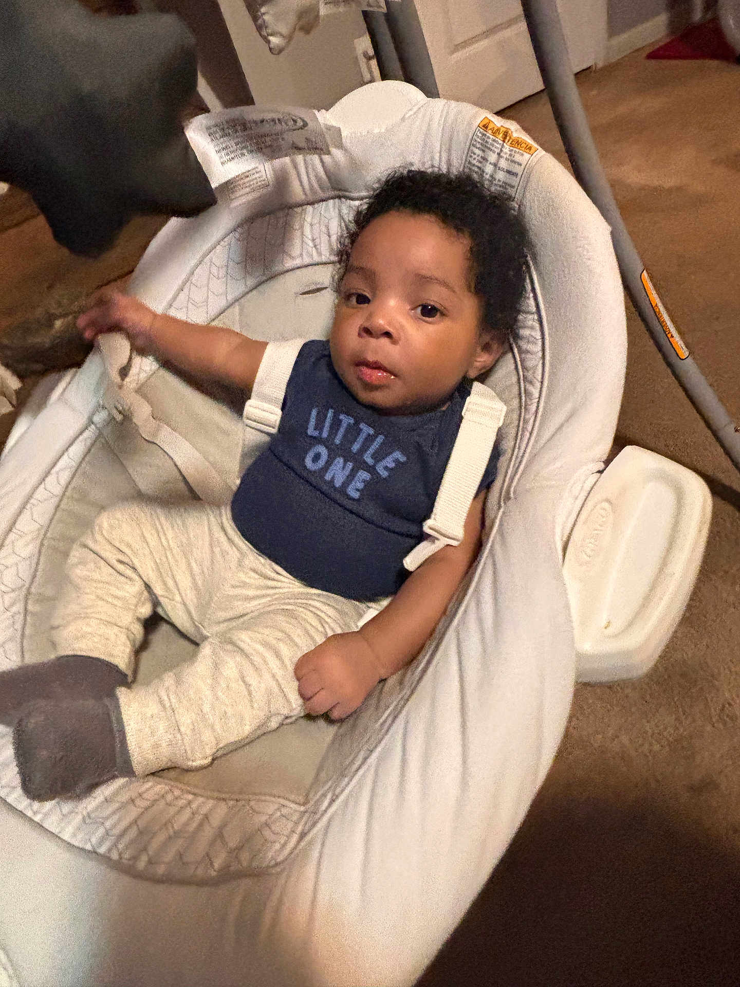 Cailand is registered to the contest to win money with this photo: baby, infant, child, bouncer, baby_seat, onesie, little_one, safety_strap, socks, carpet, indoor, portrait, face, curly_hair, relaxed, cute, homedecor, seat, toddler, young