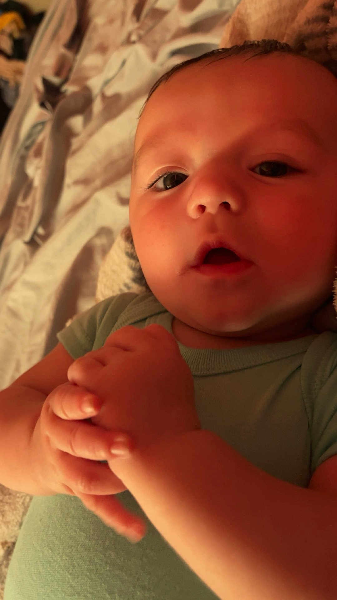 Kayden joined the competition — help win amazing prizes! baby, infant, close_up, face, hands, green_onesie, lying_down, expression, skin, young_child, indoors, blanket, soft_lighting, portrait, cute, person, child, newborn, human, cozy