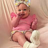 Alyssa joined the competition — help win amazing prizes! baby, infant, smiling, pink_clothing, headband, bow, sitting, blanket, cute, child, happy, sock, indoors, portrait, young_child, fingers_in_mouth, soft_texture, cozy, person, toddler