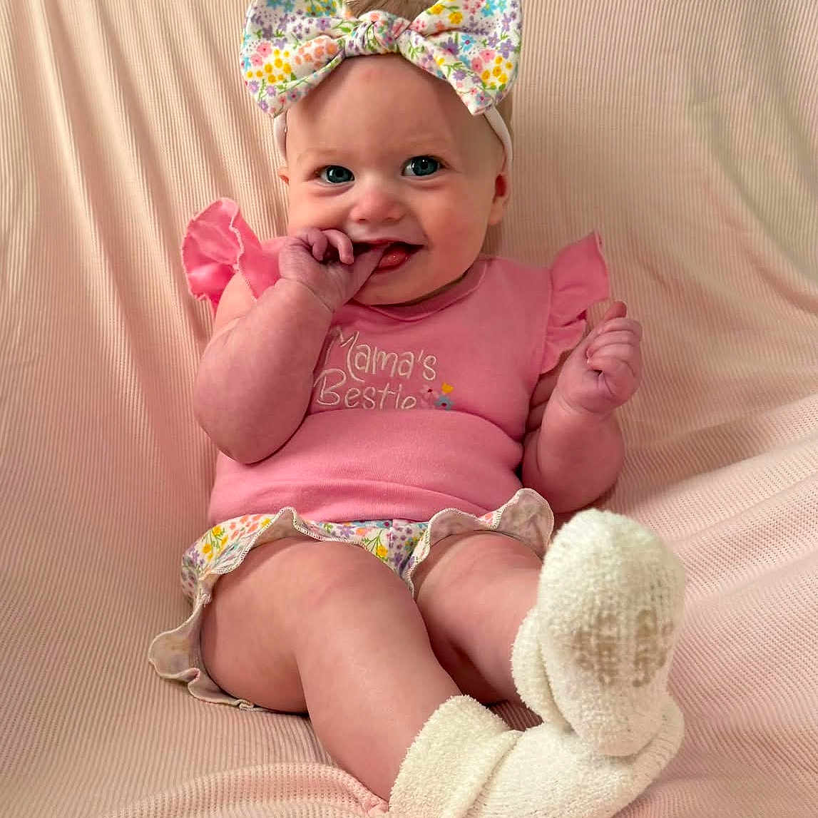 Alyssa is registered to the contest to win money with this photo: baby, child, pink_clothing, headband, bow, socks, smile, fingers, sitting, blanket, cute, happy, infant, portrait, soft_texture, baby_girl, indoors, cozy, playful, colorful