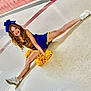 Teagan joined the competition — help win amazing prizes! cheerleader, pom_poms, split, hallway, lockers, sneakers, blue_uniform, yellow_trim, hair_bow, curly_hair, smiling, girl, youth, indoor, tiled_floor, athletic_pose, performance, school_spirit, white_shoes, portrait