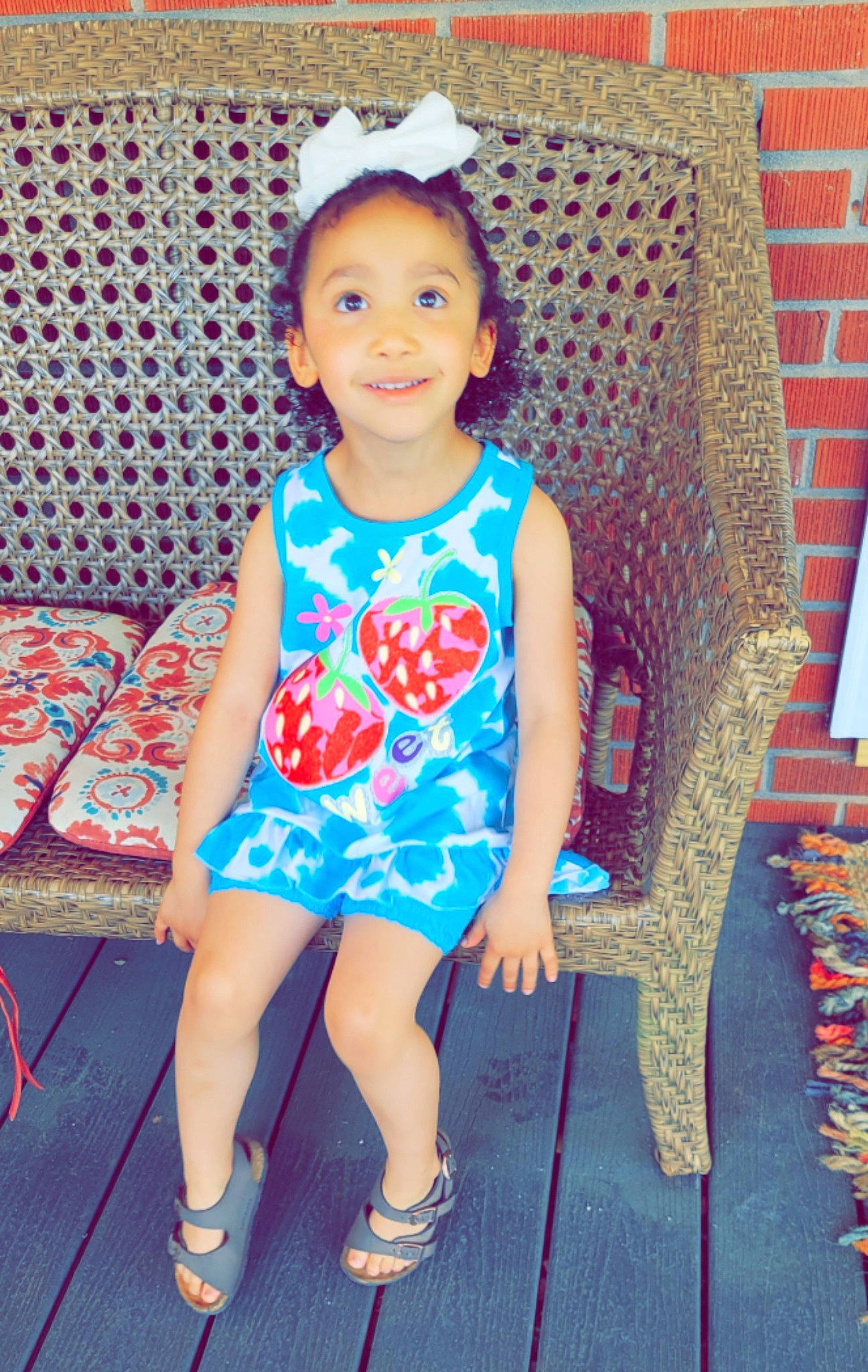 Makenna is registered to the contest to win money with this photo: arm, baby_toddler_clothing, chair, electric_blue, eye, face, hairstyle, happy, joy, leisure, magenta, pattern, person, pink, sandal, shoe, sleeve, smile, t_shirt, textile