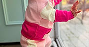 Hazel is registered to the contest to win money with this photo: baby, child, pink_bow, window, glass_door, curious, standing, indoors, colorful_clothing, cute, expression, face, headband, foot, floor, natural_light, portrait, young_child, warm_colors, home