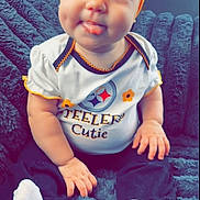 Oaklynn joined the competition — help win amazing prizes! baby, child, infant, headband, orange, bow, tongue, cute, smile, white_socks, black_pants, shirt, text, sitting, blanket, cozy, portrait, face, hands, playful