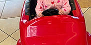 Oaklynn joined the competition — help win amazing prizes! baby, child, pacifier, toy_car, indoor, floor_tiles, pink_clothing, seat, steering_wheel, face, eyes, hair, car_toy, smile_painting, playtime, infant, cute, expression, seat_belt, colorful