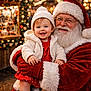 baby, beard, child, christmas, decorations, festive, glasses, gloves, happy, hat, holiday, lights, market, outdoor, portrait, red_clothing, santa_claus, seasonal, smiling, white_jacket