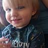 toddler, child, blond_hair, smiling, messy_shirt, indoor, person, young_child, casual_clothing, face, cute, baby, portrait, sitting, hand, blue_shirt, messy, happy, small_person, human