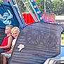 child, children, boys, carnival_ride, ride_car, number_4, outdoor, daylight, smile, serious, light_bulbs, metal_structure, cartoon, pirate, trees, vehicle, funfair, amusement_park, blond_hair, casual_clothing