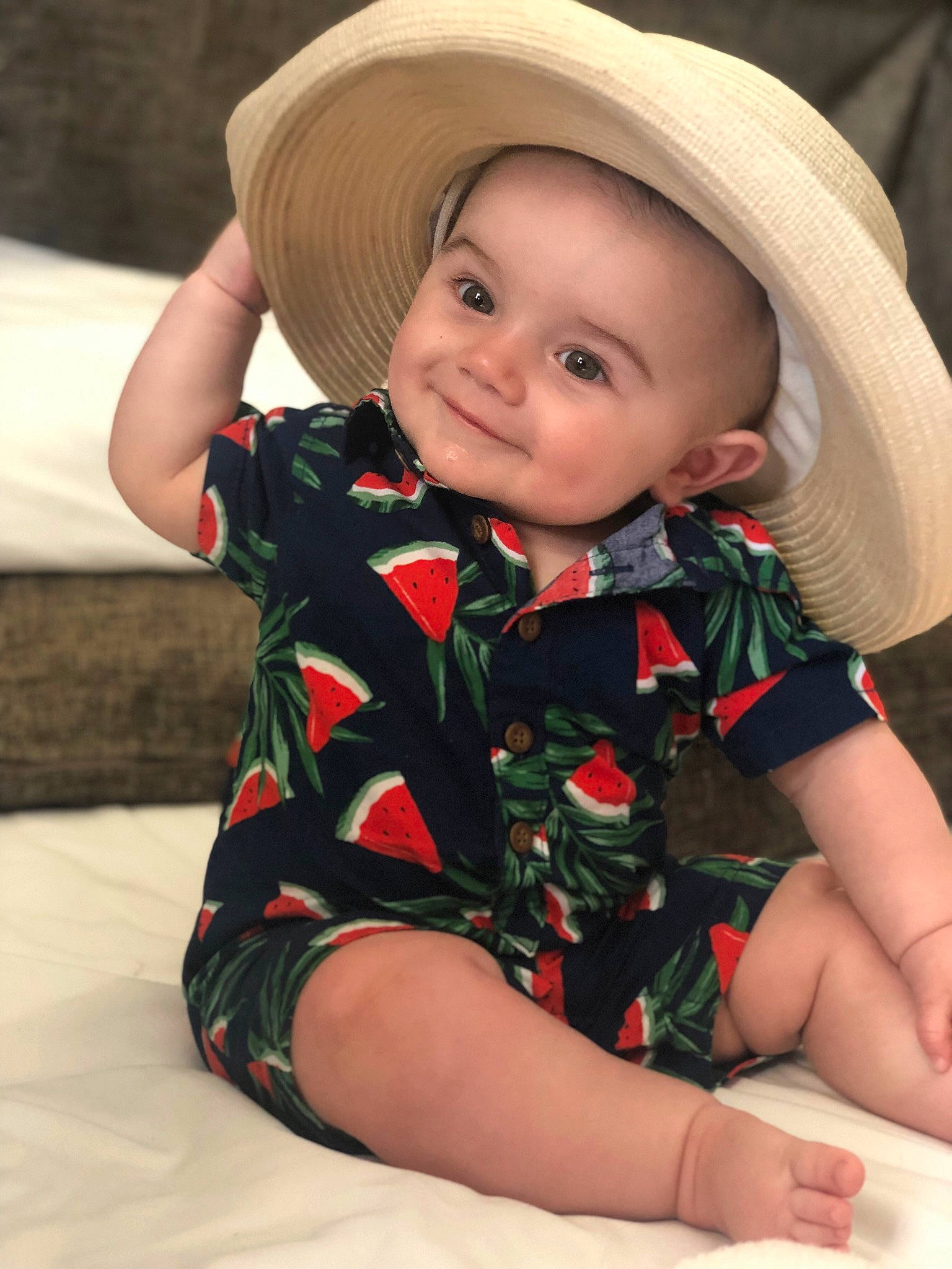 Killian is registered to the contest to win money with this photo: baby, baby_products, child, child_model, clothing, fashion_accessory, hat, headgear, joy, leg, person, sitting, skin, sleeve, sun_hat, toddler
